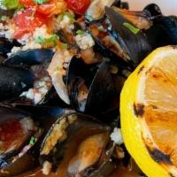 Mussels · steamed & in a spicy garlic tomato white wine sauce, topped with onion & couscous, garnished...