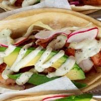 Shrimp Tacos · Mildly spicy grilled shrimp, red and white cabbage, avocado, creamy cilantro sauce.