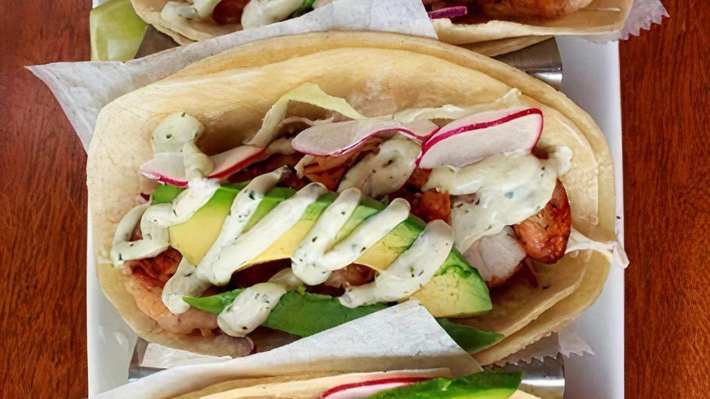 Shrimp Tacos · Mildly spicy grilled shrimp, red and white cabbage, avocado, creamy cilantro sauce.