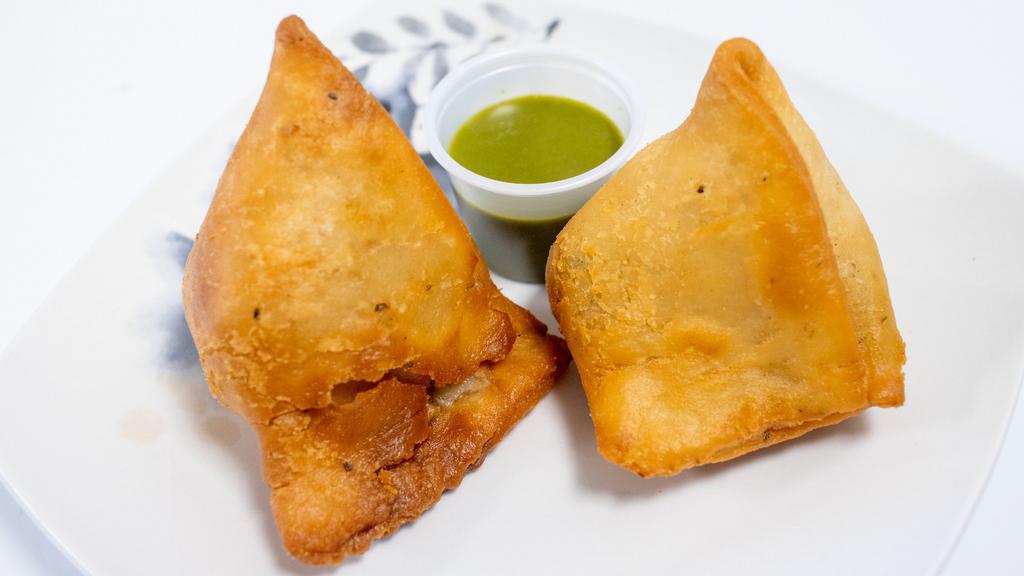 Veg Samosa (2 Pieces) · Crispy pastries filled with potatoes, peas and spices. Served with chutney of your choice - cilantro sauce chutney or tamarind sauce chutney.