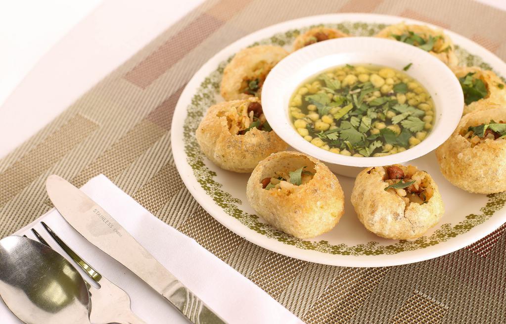 Pani Puri · Consisting of a hollow, crispy-fried puffed ball that is filled with potato, chickpeas, onions, spices, and flavored water.