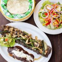 Arrachera Poblana · Skirt steak with poblanos and onions, mole enchilada and guacamole.