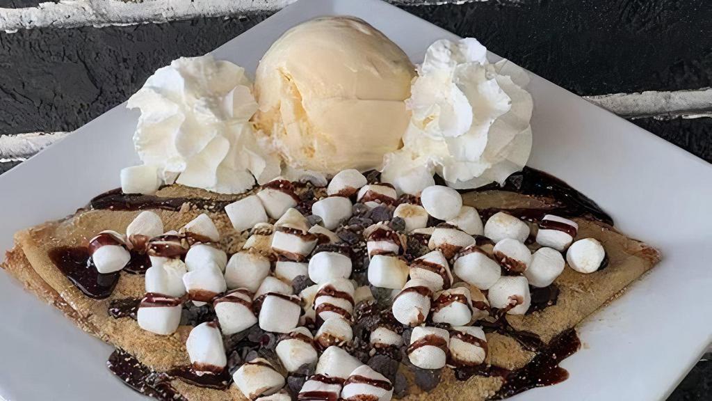 S'Mores Crêpe · A campfire-inspired crepe covered in chocolate chips, graham cracker crumbs, mini marshmallows, and chocolate sauce.