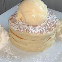 Plain Pancakes · A stack of our homemade pancakes, dusted with powdered sugar.  Comes topped with whipped cre...