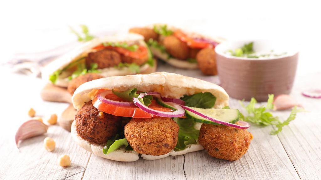 Falafel Sandwich With Fries · Homemade pita bread filled with delicious falafel, fresh lettuce, tomatoes, and hot and white sauces. Served with fries on the side.