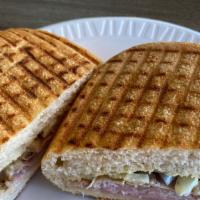 El Cubano · El Cubano panini as done down in Miami. Deluxe Ham, crispy bacon, Swiss cheese, sliced pickl...