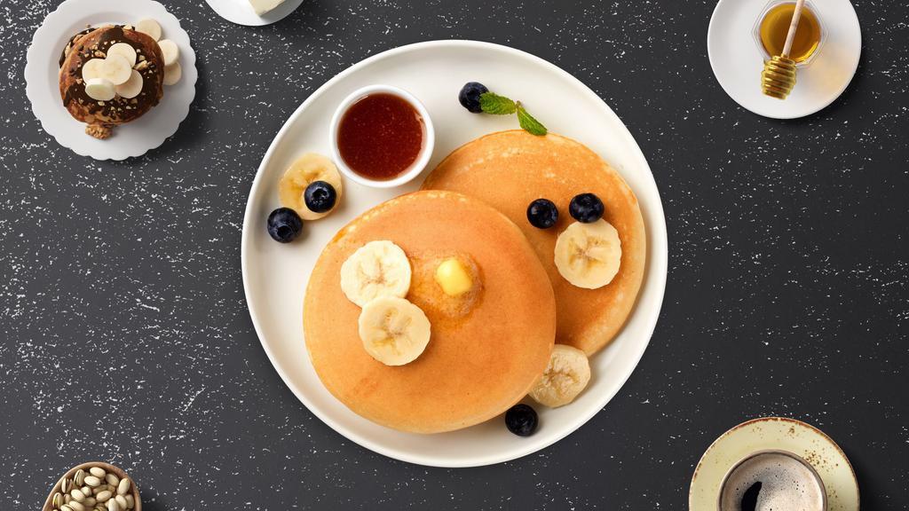The Banana Pancakes · Fluffy pancakes cooked with care and love served with bananas, butter and maple syrup.