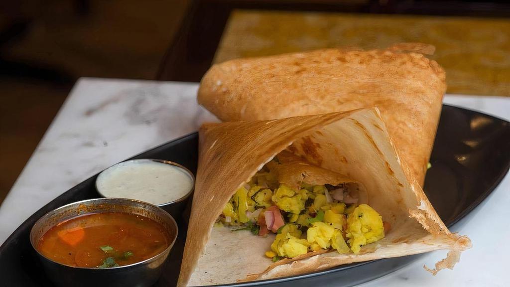 Masala Dosa (Vgf) · A crispy rice and lentil crepe filled with with spiced mashed potatoes and onions.    Served with sambar and green chutney. Vegan & Gluten Free .