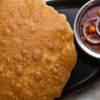 Chana With Bhatura (V) · A savory chickpea curry served with puffed bread. Vegan.