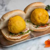 Vada Pav (V) · Potato dumplings with garlic and cilantro chutney on a roll. Vegan.