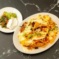 Nachos Grande (Al Rey) · Tortilla chips topped with refried beans, ranchera & enchilada sauce, melted cheese, served ...