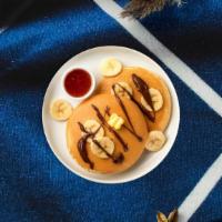 Choconana Pancakes · Three chocolate pancakes loaded with banana and walnut.