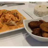 Pescado A Lo Macho · Fried filet topped with seafood in sauce, served with rice.