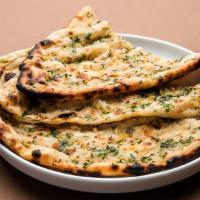 Garlic Naan · Flat bread sprinkled with crushed garlic, cheese and baked in tandoor oven.