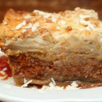 Mousaka · Layers of ground beef, eggplant, potatoes, béchamel sauce on top, served with lemon potatoes