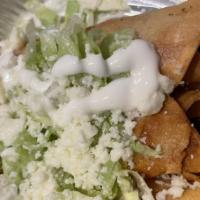 Flautas De Pollo · Three pieces. Corn tortilla filled with seasoned chicken topped with lettuce, sour cream, fr...