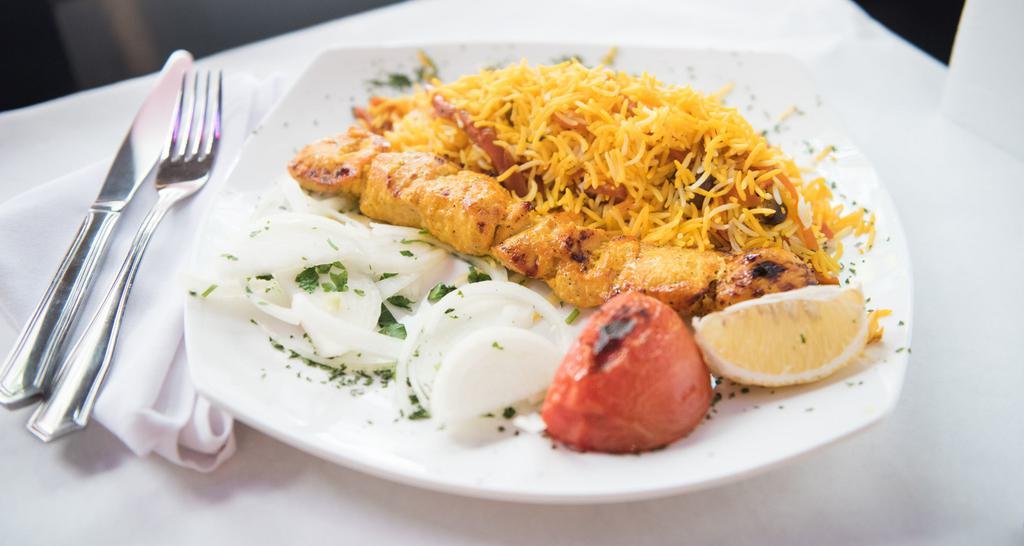 Shirin Polo · Saffron rice topped with almonds, pistachios, orange strips, carrot strips, rose water, and cardamom served with cornish hen.