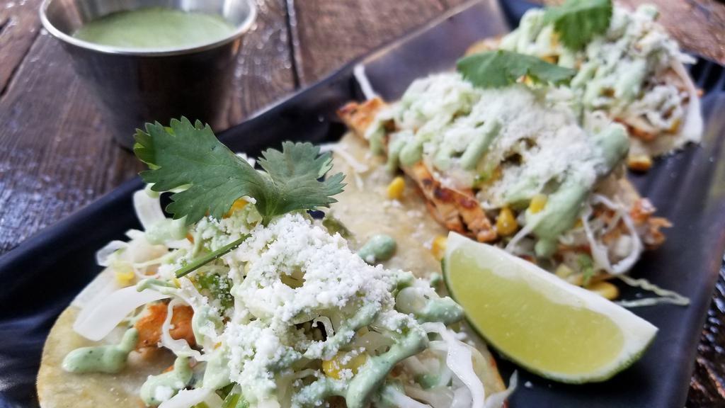 Chicken Tacos · Grilled chicken breast, jalapeno salsa, yuzu cabbage and grilled corn slaw, cilantro crema and cotija cheese with aji sauce (peruvian hot sauce) on the side. Hot and spicy.