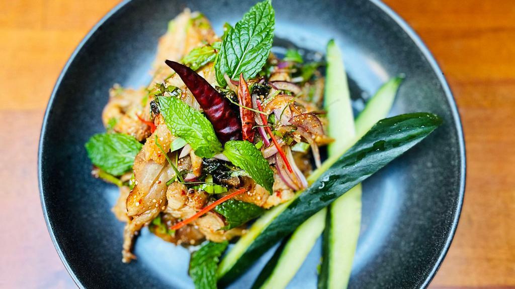 Yum Kaw Moo · Grilled pork salad tossed in chili and various fragrant Thai herbs, lime dressing, toasted rice powder and crunchy shallot.