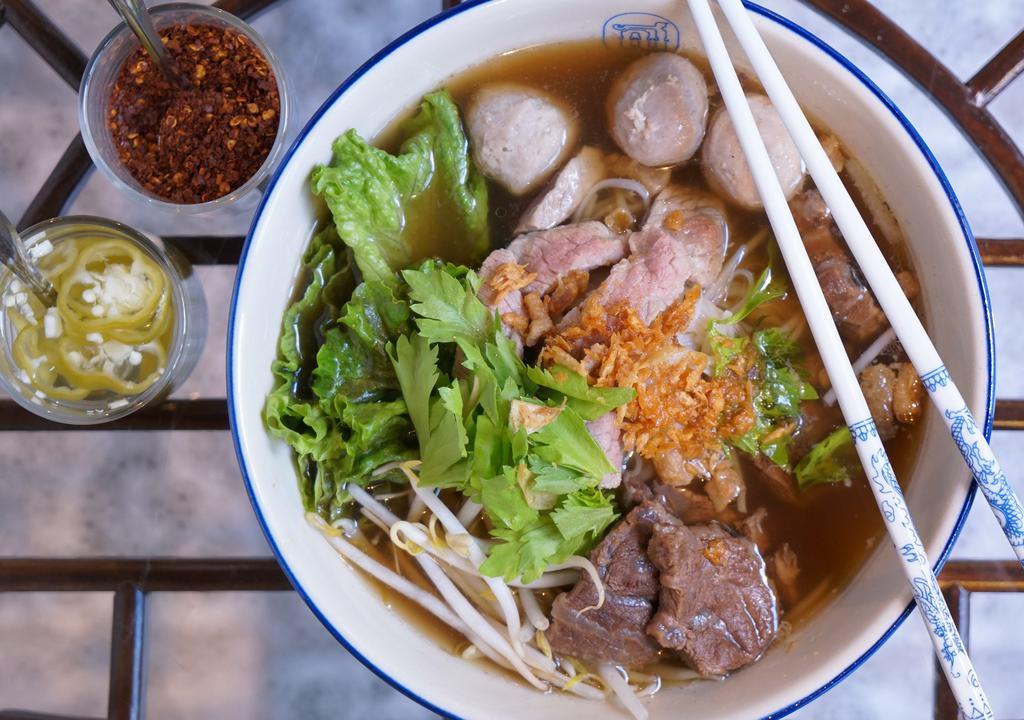Stewed Beef Noodle Soup · House recipe herb-based soup, served with rice noodles, stewed beef, homemade beef balls, bean sprouts, lettuce, scallion, and cilantro.