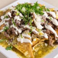Stake Chilaquiles · A handful of fried tortilla chips topped with powered Cotija cheese, melted Monterey Jack ch...
