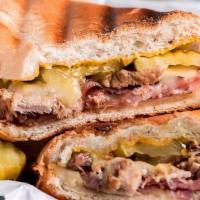 Cuban Sandwich · Roast pork layered with ham, swiss cheese, and pickles comes with french fries