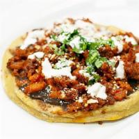 Huarache Al Pastor  · Oval real corn tortilla topped with refried beans, meat of choice, lettuce, cotija cheese an...