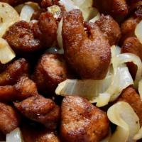 Masitas De Cerdo · Succulent pork chunks fried and topped with sautéed onions.