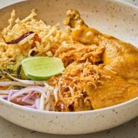 Khao Soi Chicken · Northern style curry noodle soup with chicken, pickle, cilantro, red onion, dried chili, bea...