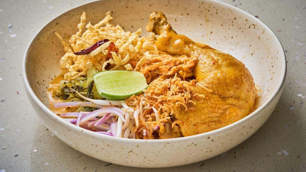 Khao Soi Chicken · Northern style curry noodle soup with chicken, pickle, cilantro, red onion, dried chili, bean spouts and crispy egg noodle.