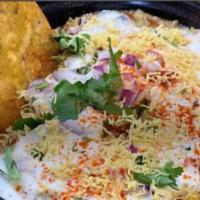 Aloo Tikki Chaat · Fried potato patties topped with tangy-sweet tamarind chutney and green chutney along with c...