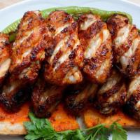 Chicken Wings (10) · Marinated and perfectly char grilled crispy chicken wings served over rice pilaf and a cabba...