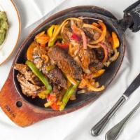 Fajitas Steak · Sizzling marinated strips of steak, on a bed of sauteed onions, and green peppers. Served wi...