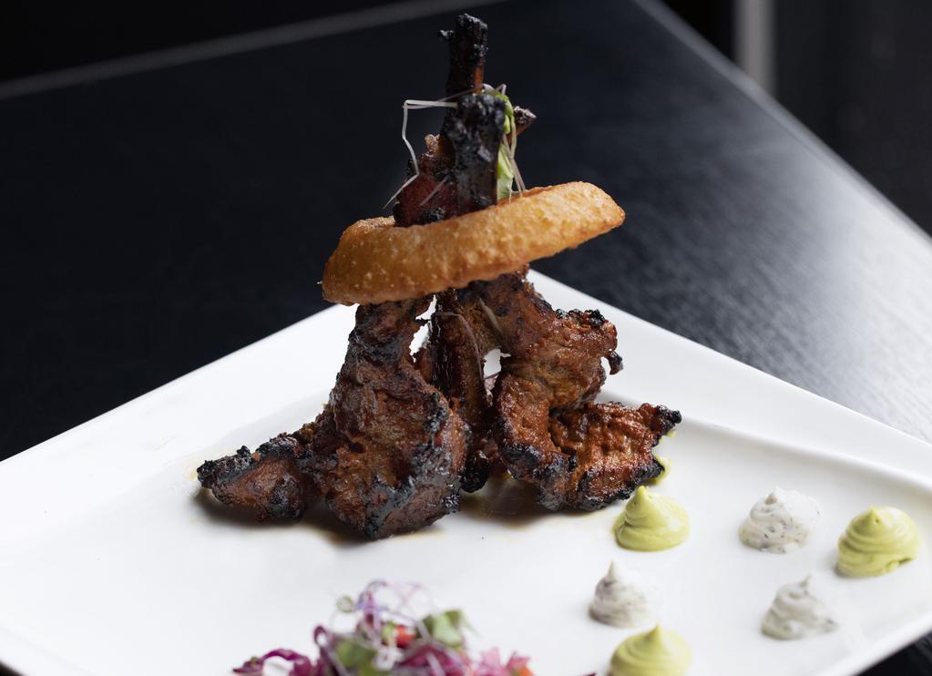 Aroqa Lamb Chop · Marinated in aRoqa’s blend of spices served with yogurt mint raita and topped with an onion ring.