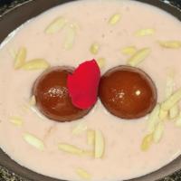 Rose Pudding With Gulab Jamun · Fried milk and flour balls soaked in sugar syrup served over rose flavored milk pudding.