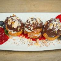 Profiterole · House made fluffy cream puff filled with pastry cream and dipped in chocolate.