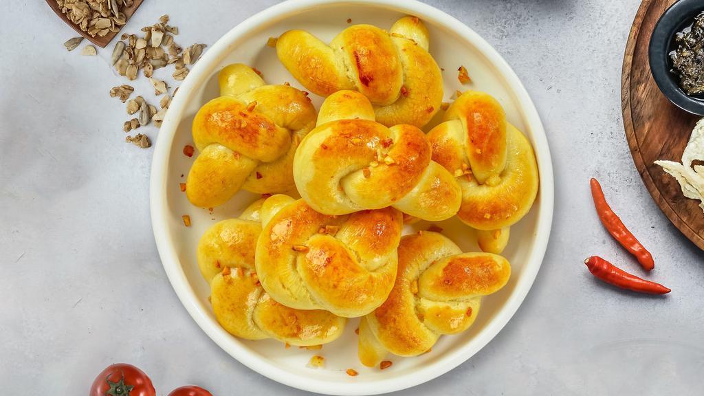 Garlic Knots · A classic Italian pizzeria snack, garlic knots are strips of pizza dough tied in a knot, baked and then topped with melted butter, garlic and parsley.