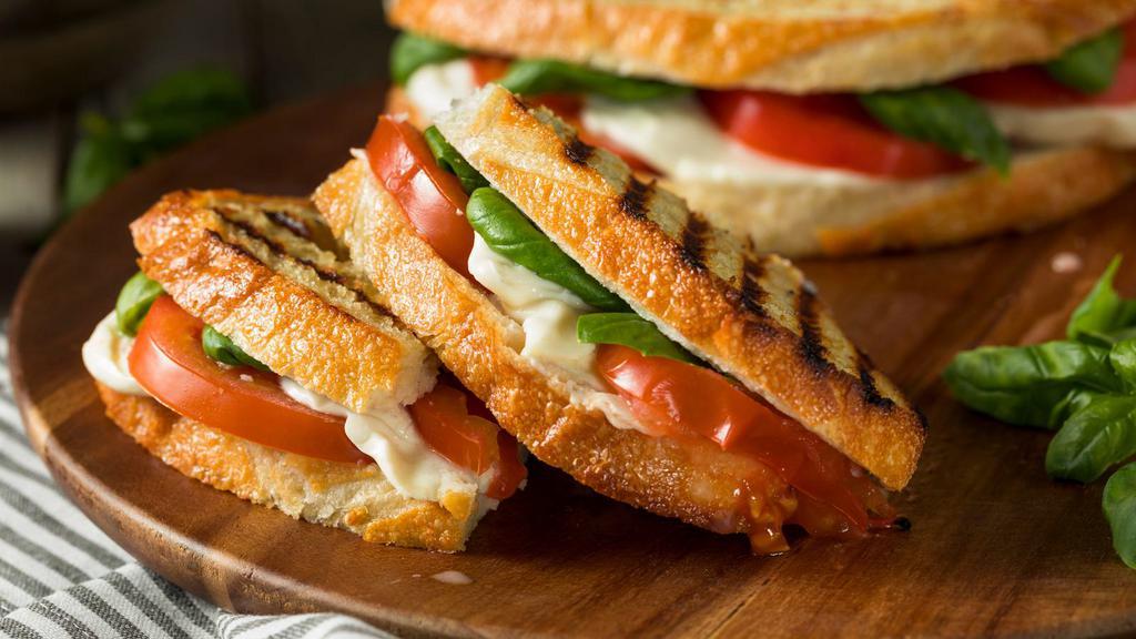 Meatless Panini · Grilled Panini Sandwich made with Mozzarella cheese, plum tomatoes, basil, spinach, sundried tomato, romaine lettuce, and pesto sauce.