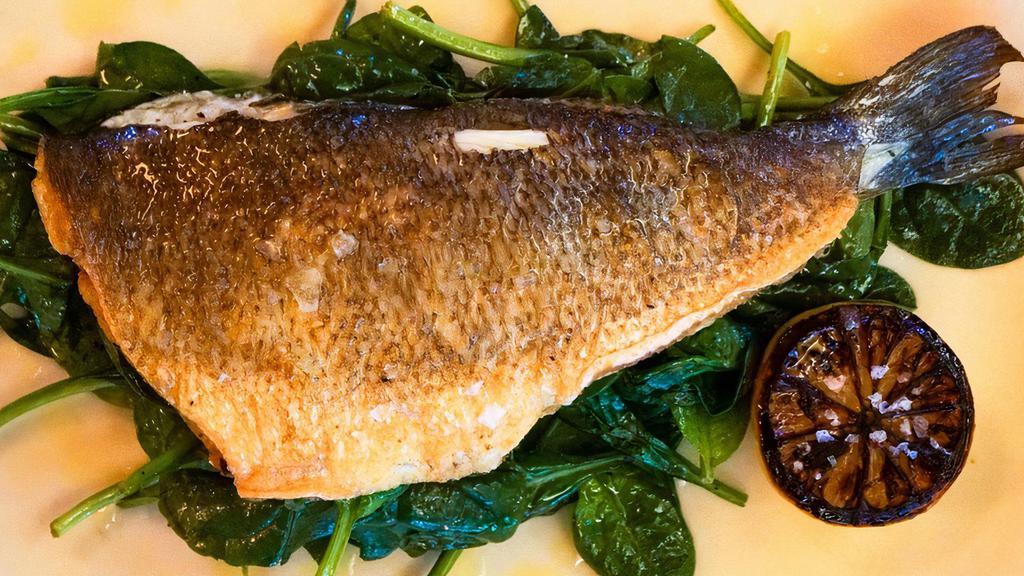 Whole Roasted Branzino · Served with sauteed spinach and grilled lemon.