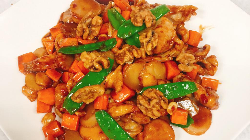 Chicken With Three Different Nuts · Sliced chicken sautéed with water chestnuts and snow peas in a brown sauce and garnished with walnuts, peanuts, and cashew nuts.