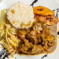 Goat Curry · Served with rice, vegetables, and plantain.