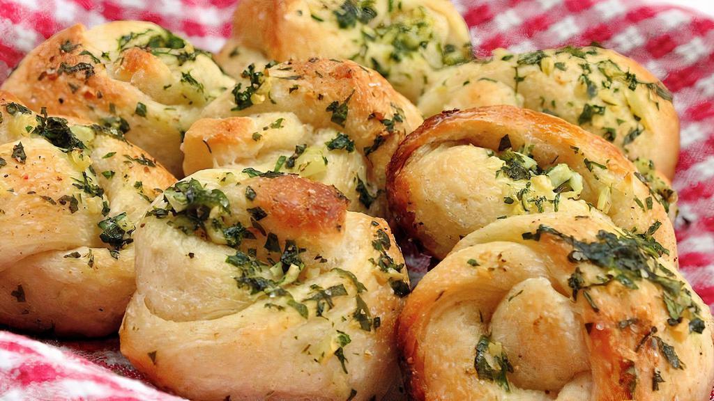 Garlic Knots 4 Pcs · Garlic Knots are Strips of Pizza Dough tied in a Knot, Baked, & then Topped with Melted Butter, Garlic, and Parsley.