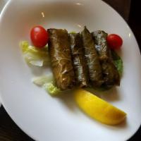 Grape Leaves · Grape leaves stuffed with rice, tomato, mint, lemon, parsley, and seasoning cooked in olive ...