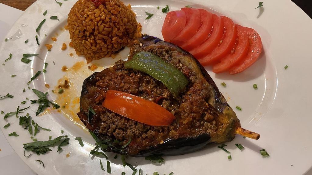 Stuffed Eggplant · Pan-fried eggplant stuffed with ground meat, tomatoes, parsley, onion, bell papers, and seasonings. Served with rice.