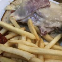 Reuben Sandwich · Corned beef on pastrami and sauerkraut topped with melted Swiss cheese on rye bread. Served ...