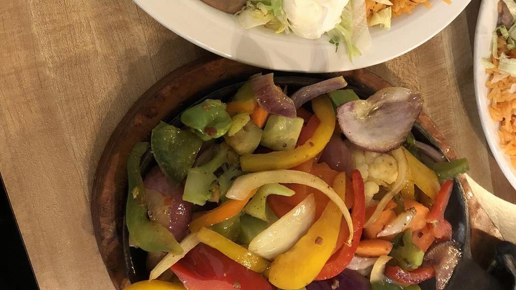 Vegetable Fajitas · Grilled vegetables with onions, tomatoes and bell peppers. Served with guacamole salad, sour cream, rice, beans and tortillas.
