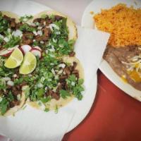 Tacos Carne Asada · Four corn tortillas stuffed with roast beef, rice, beans, cilantro and onions.