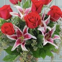 Loving Gaze · Rich red roses and elegant lilies designed in a red vase.