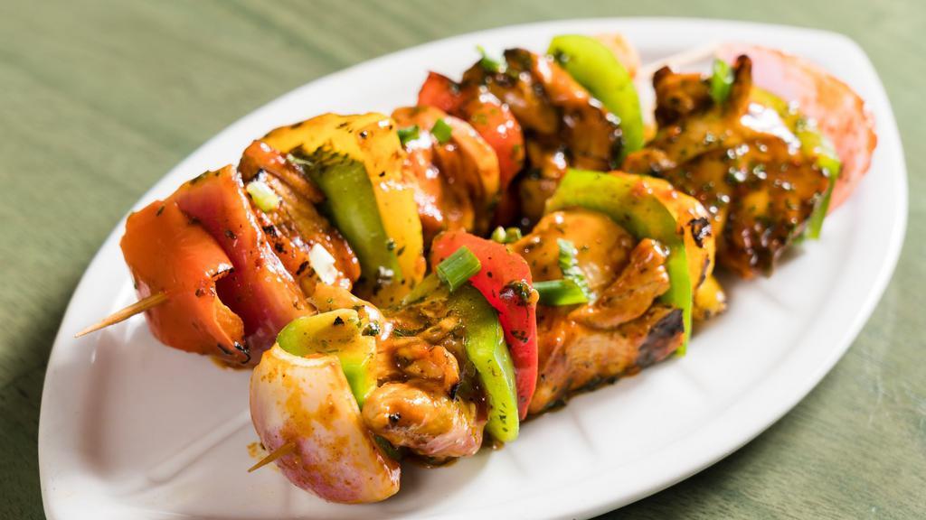 Chicken Kabob · Flame grilled chicken cubes on two skewers with grilled peppers and onions.