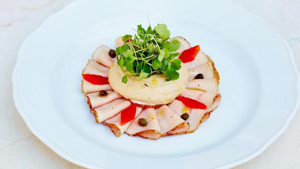 Vitello Tonnato* · traditional slow-roasted thinly sliced veal tenderloin, pickled bell pepper, yellowfin tuna sauce, pickled capers.  *Consuming raw or under-cooked meats, poultry, seafood, shellfish or eggs may increase your risk of foodborne illness.